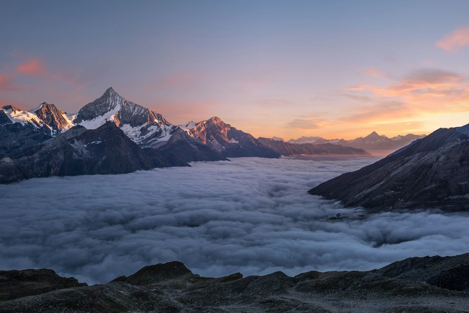 Peaks rising above a sea of cloud at first light